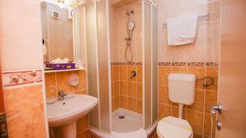 Un baño con ducha, lavabo e inodoro.