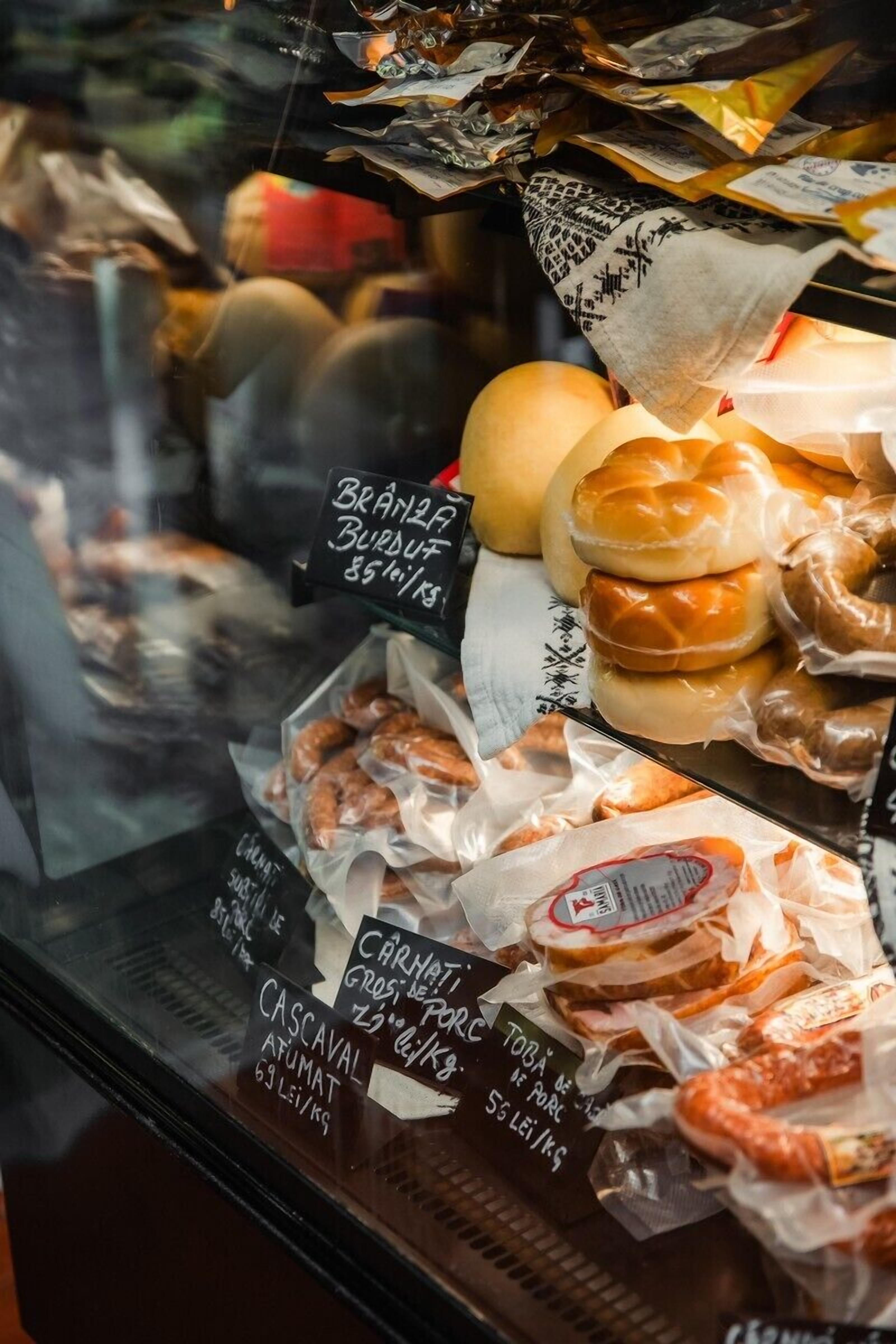 A bakery display case with various baked goods like donuts and pastries, each labeled with prices and names.