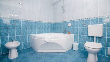 A bathroom with a bathtub, a sink, a toilet, and a shower.