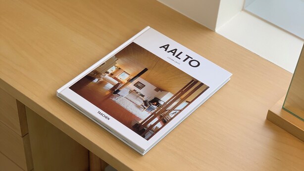 A magazine titled "Aalto" on a wooden desk with a round wooden stool. - Villa Tuuli (Jeju City)