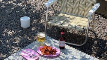 A glass-topped outdoor hot tub with a metal faucet, surrounded by a tiled floor.