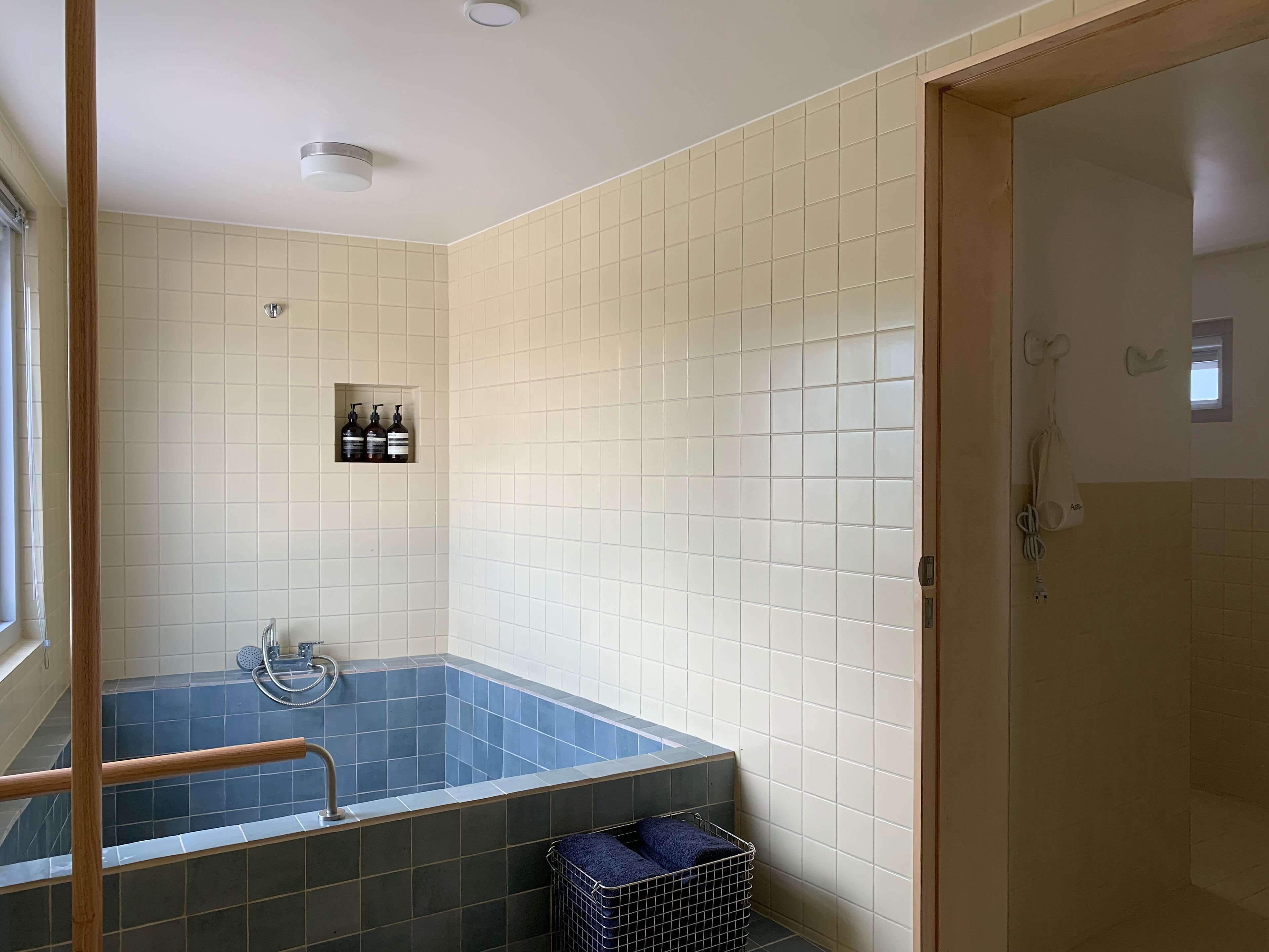 Une salle de bain avec une baignoire, une douche et des toilettes. On y trouve des articles de toilette accrochés au mur et un porte-serviettes.