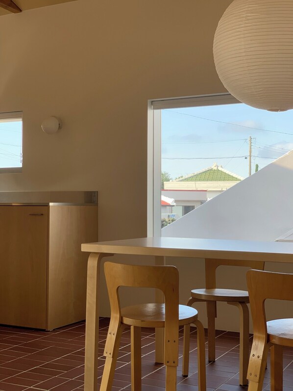 A kitchen with a window, a wooden table, and two chairs.