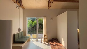 A modern interior with a built-in bench, a staircase, and a sliding glass door leading to an outdoor area. - Villa Tuuli (Jeju City)