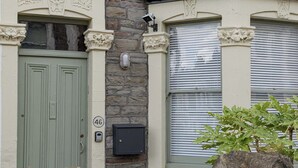 A stone facade with a green door, a mailbox, and a window with shutters. - Beautiful 3 Bedroom Home in Bristol (Bristol)