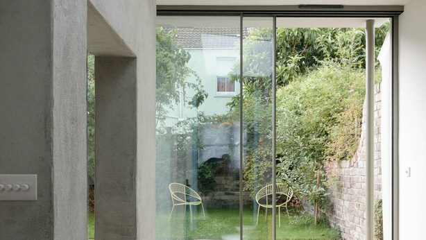 A modern interior with a skylight, a dining area with a table and chairs, and a view of a garden through large glass doors. - Beautiful 3 Bedroom Home in Bristol (Bristol)