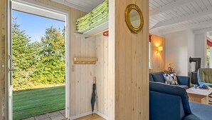 A room with a wooden interior, a blue sofa, a mirror, and a view of a green landscape. - "Leani" - 150m from the sea by Interhome (Ørsted)