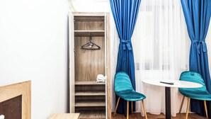 A room with a wooden wardrobe, a table with two chairs, and a window with blue curtains. - Stefan Building Mamaia Nord (Mamaia-Sat)
