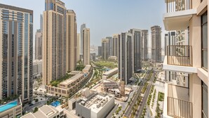 Un edificio residenziale di grandi dimensioni con numerosi balconi, una piscina e un paesaggio urbano curato.