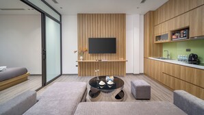 A modern living area with a sofa, ottoman, and a glass coffee table. - Minerva Aparthotel Hanoi (Hanoi)