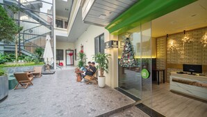 A modern hotel lobby with a glass wall, a Christmas tree, and a reception desk. - Minerva Aparthotel Hanoi (Hanoi)