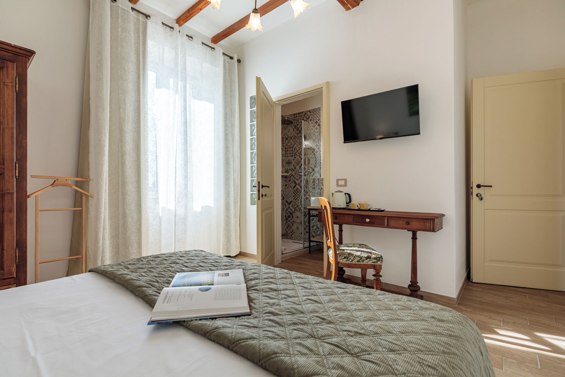 Une chambre à coucher comprenant un lit, un bureau, une chaise, une télévision et une armoire.