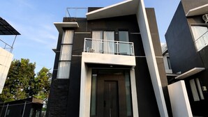 A modern two-story house with a balcony, a front door, and a paved driveway. - Arrayyan Executive Village Complex Batu (Batu)