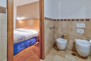 Een douche, een bidet, handdoeken, shampoo