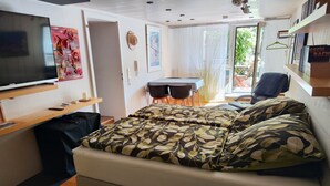 Une chambre à coucher avec un lit, une télévision, un bureau et une chaise.