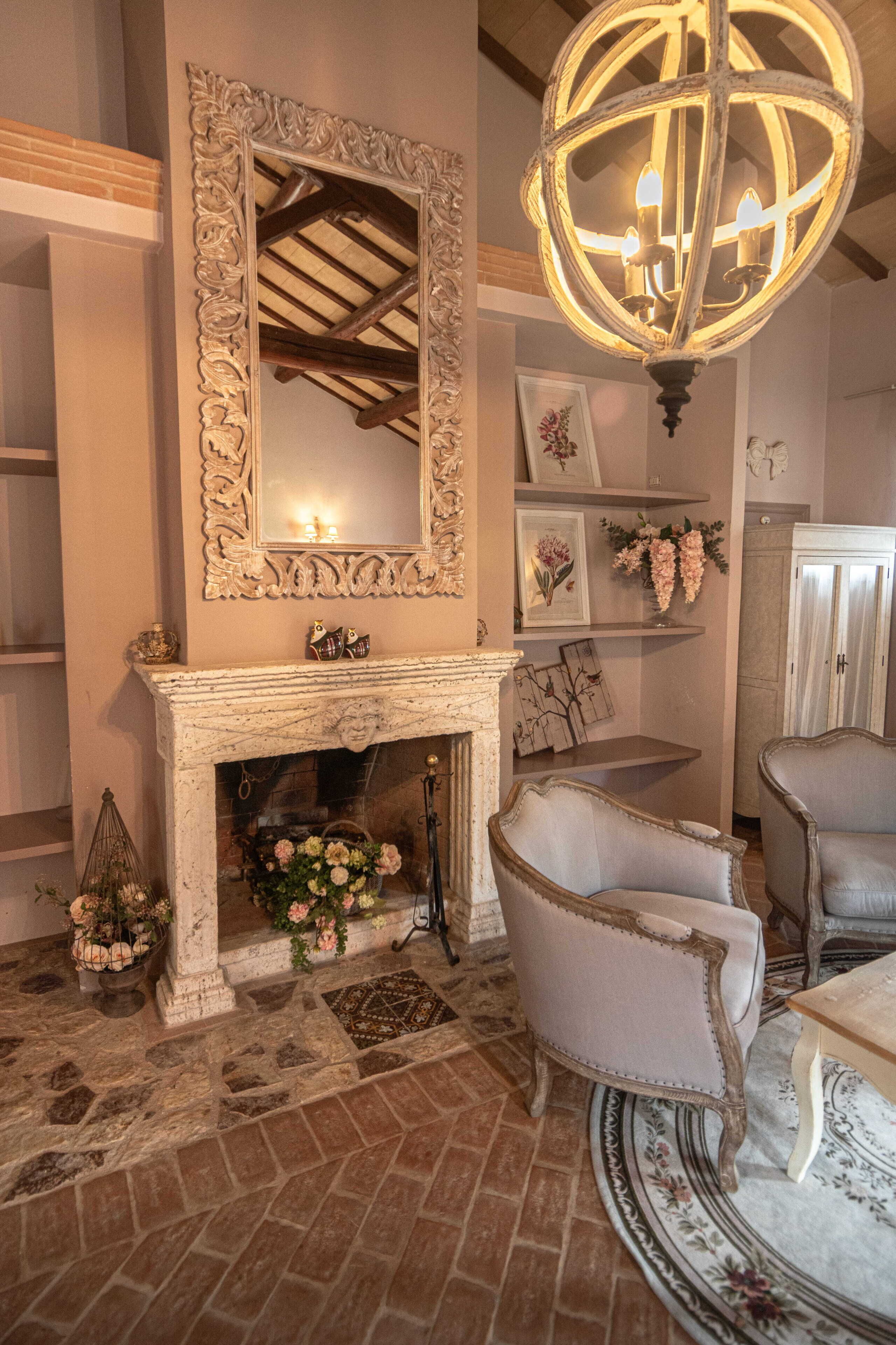 A room with a fireplace, ornate mirror, and a chandelier.