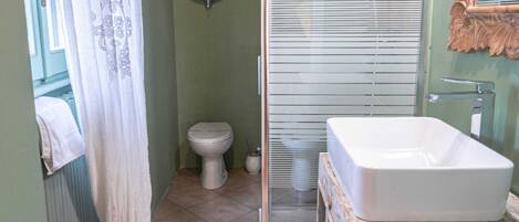 A bathroom with a shower, toilet, and sink.