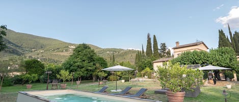 Piscine extérieure en saison, chaises longues