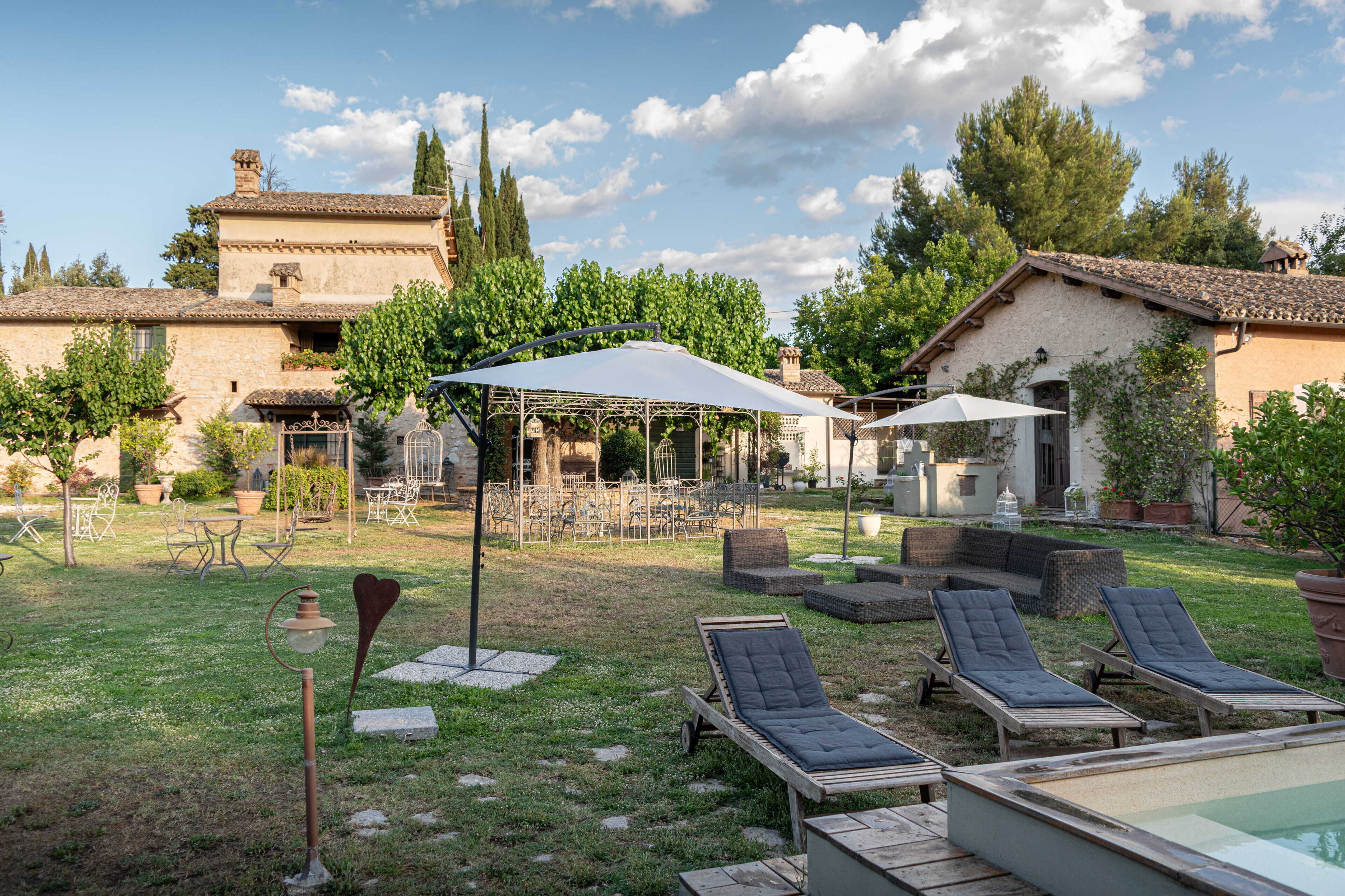 Un patio con mobiliario exterior, piscina y una pérgola que ofrece sombra.