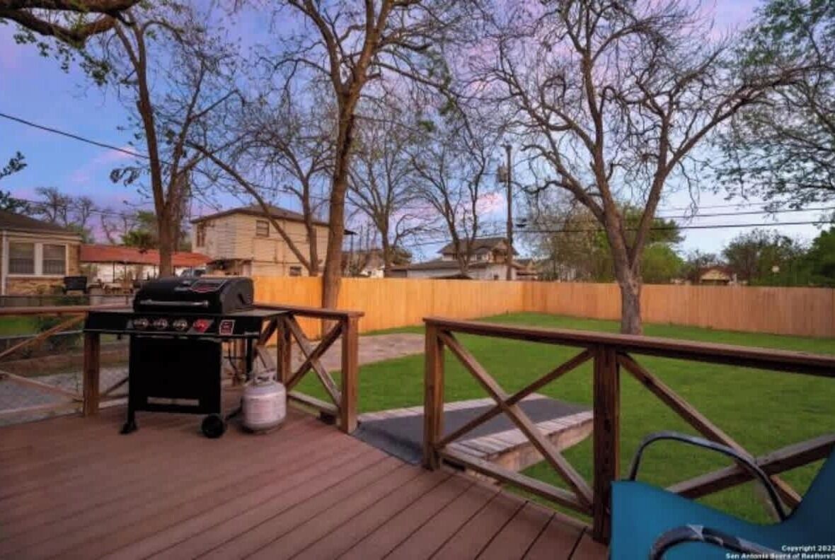 Eine Holzterrasse mit Grill und Wasserspender.