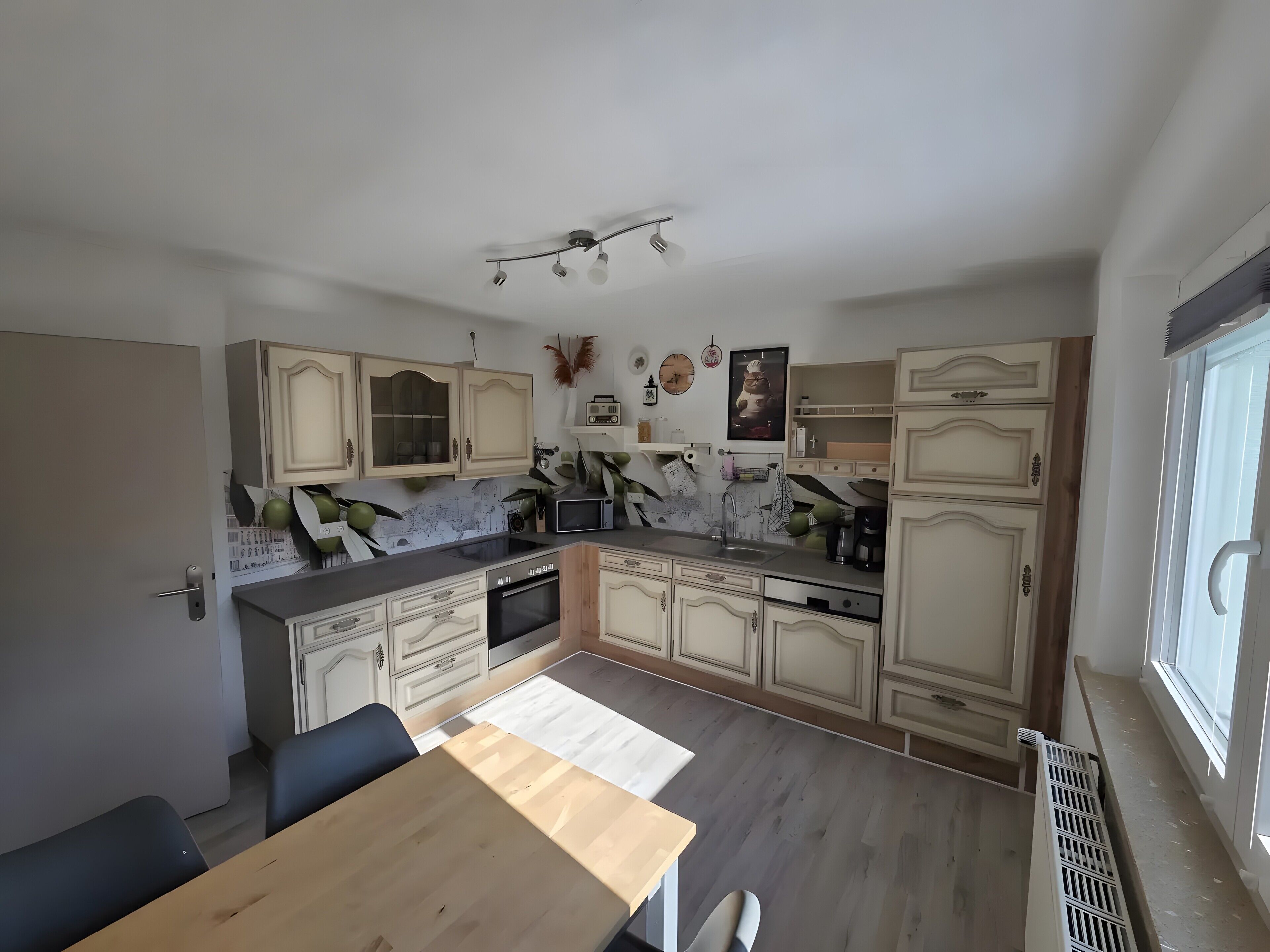 A kitchen with a dining table, cabinets, a microwave, and a stove.