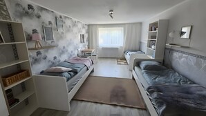Une chambre à coucher comprenant un lit, deux tables de chevet, un bureau et une chaise.
