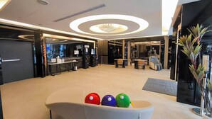 A modern lobby with a reception desk, seating area, and a chandelier. - Fooyee Hotel - Yizhong Branch (Taichung)