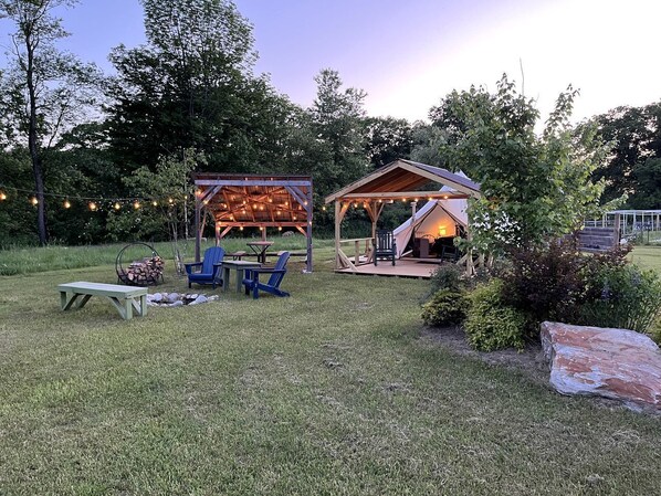 Un espace extérieur aménagé en terrasse, avec un coin salon abrité, une table et des chaises.