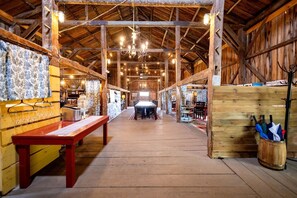 A spacious hall with wooden beams, a central table, and a rustic ambiance.