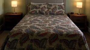 A bedroom with a bed, two bedside lamps, a ceiling fan, and a window with blinds. - Idyllic Cottage Rental in Waynesville Perfect for a Great Smoky Mountains Getaway (Waynesville)