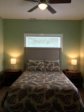 A bedroom with a bed, two bedside lamps, a ceiling fan, and a window with blinds. - Idyllic Cottage Rental in Waynesville Perfect for a Great Smoky Mountains Getaway (Waynesville)