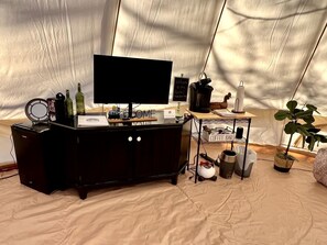 A tented area with a black entertainment unit, a coffee bar, and a welcome sign. - Rustic Bell Tent on a Texan Farm, Nestled in the Sam Houston National Forest, Perfect for a Weekend Getaway (Cleveland)