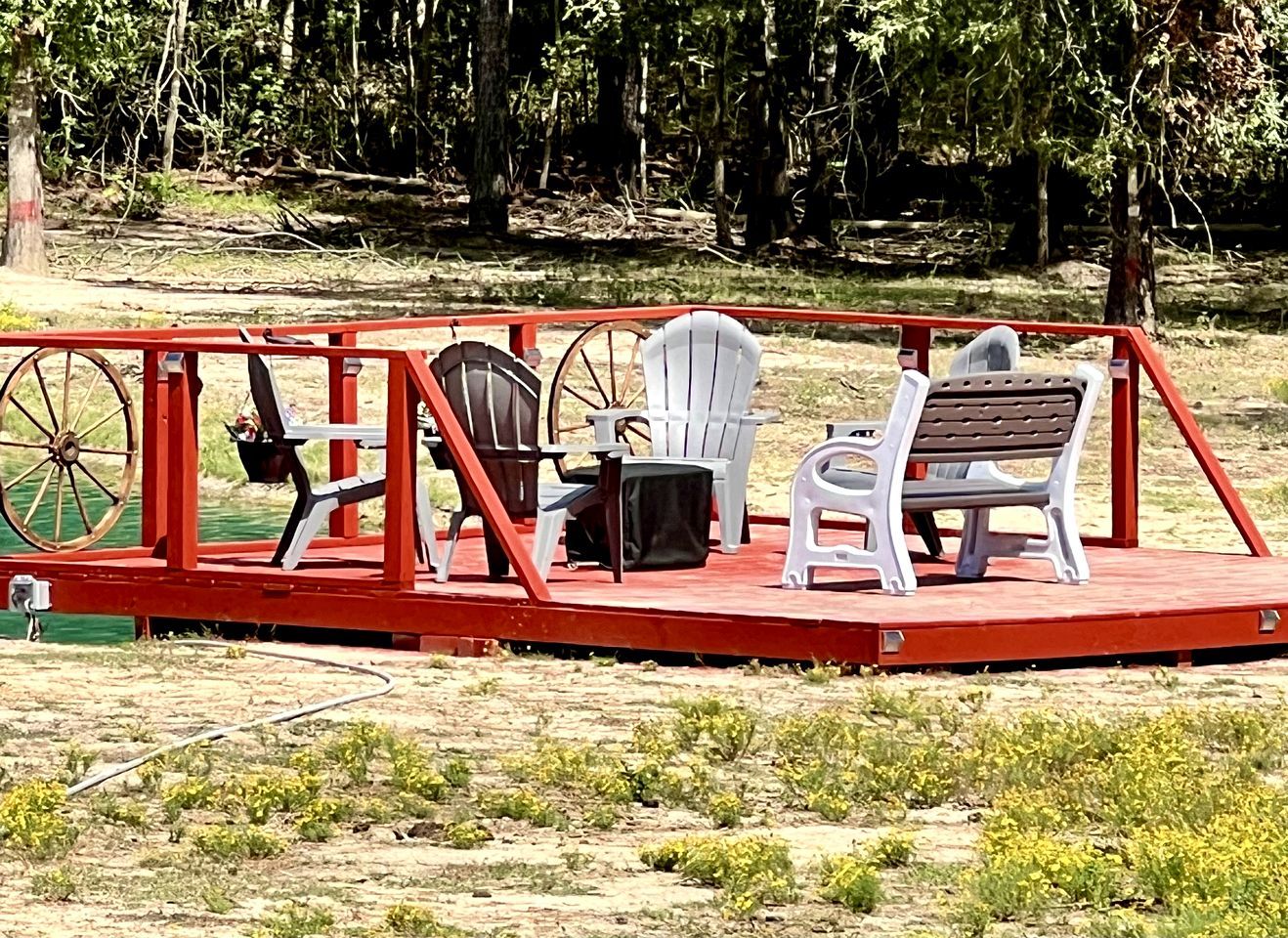 A stage with a red frame, a black chair, a white chair, and a bench.
