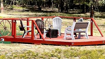 A stage with a red frame, a black chair, a white chair, and a bench.