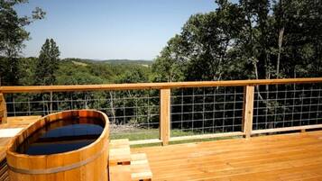 A wooden deck with a hot tub and a wooden fence.