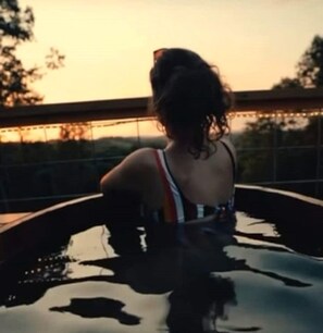 A person in a swimming pool with a sunset in the background.
