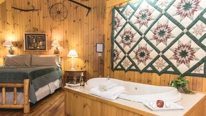 Een houten kamer met een bed, een badkuip en een wanddecoratie met quiltwerk.