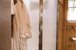 A bathroom with a wooden door, a towel rack, and a window.