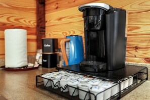Une machine à café, une bougie et une cafetière sur un plan de travail.