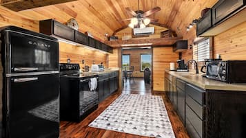 Una cocina moderna con un refrigerador Galanz negro, una estufa y un microondas.