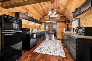A modern kitchen with a black Galanz refrigerator, a stove, and a microwave.