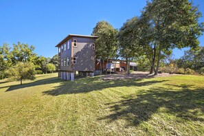 Ein modernes, zweistöckiges Haus mit Flachdach, großen Fenstern und einem gepflegten Rasen.