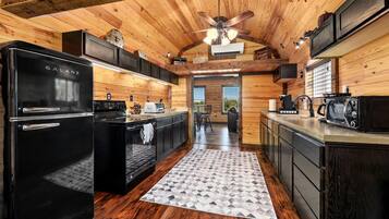 Una cocina moderna con un refrigerador Galanz negro, una estufa y un microondas.