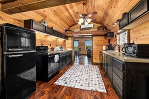 Una cocina moderna con un refrigerador Galanz negro, una estufa y un microondas.