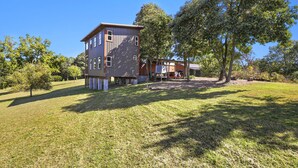 A modern two-story house with a flat roof, large windows, and a well-maintained lawn.