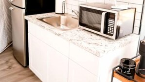 A compact kitchen with a built-in microwave, a sink, and a countertop.