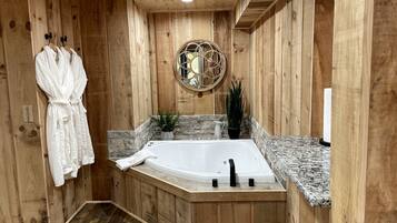 Un intérieur en bois avec une baignoire sur pieds, des murs en bois et un porte-serviettes avec des peignoirs.