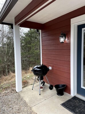 A covered porch with a grill, a lantern, and a black bucket. - Quaint Cute Cabin Incredible for a Couples Escape in Virginia (Lexington)