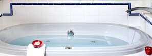 A bathtub with a faucet, a red object on the side, and a blue-tiled wall. - Lovely Suite Rental for Two at Countryside Bed and Breakfast in Warren, Vermont (Warren)