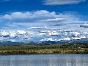 Un paysage comprenant des montagnes, une étendue d’eau et un ciel dégagé.